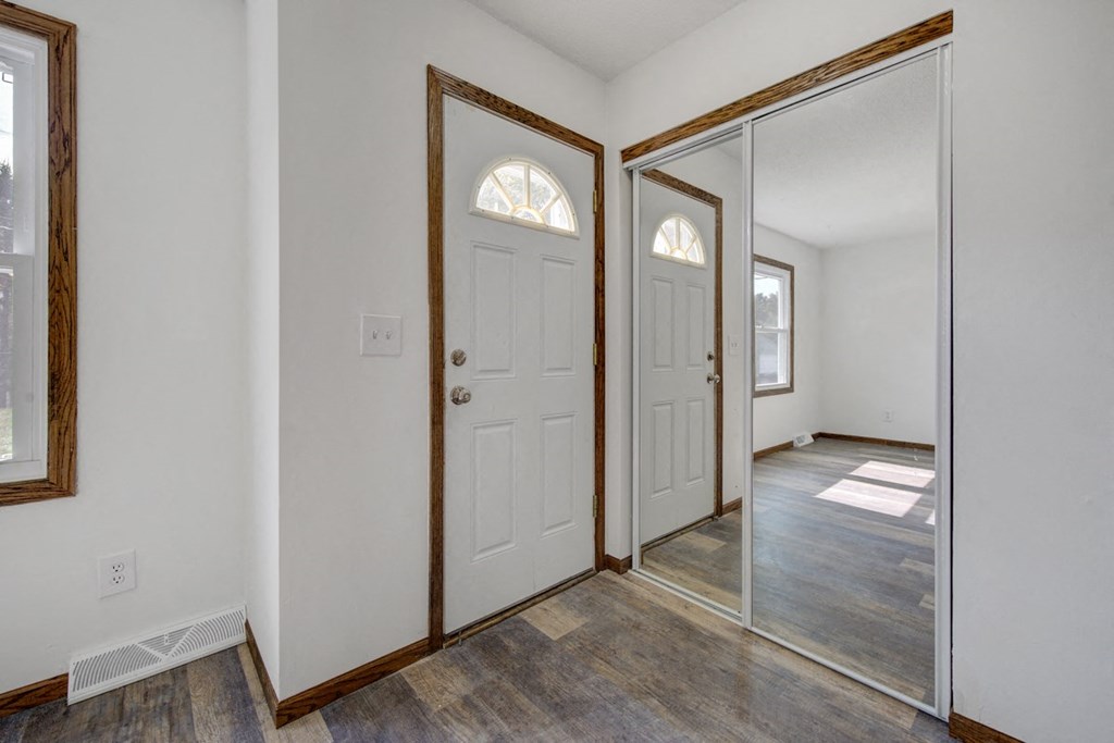 a bedroom with a white door and a mirror