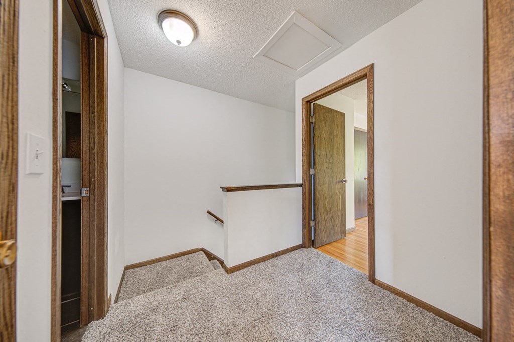 an empty room with a mirror and a door to a hallway