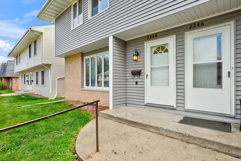 the front of a house with a white door and a porch