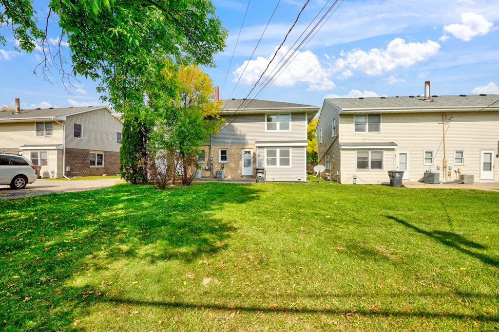 a group of houses in a yard with a green lawn
