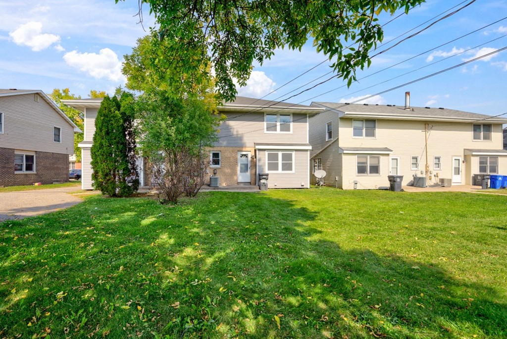a group of houses in a neighborhood with a green lawn
