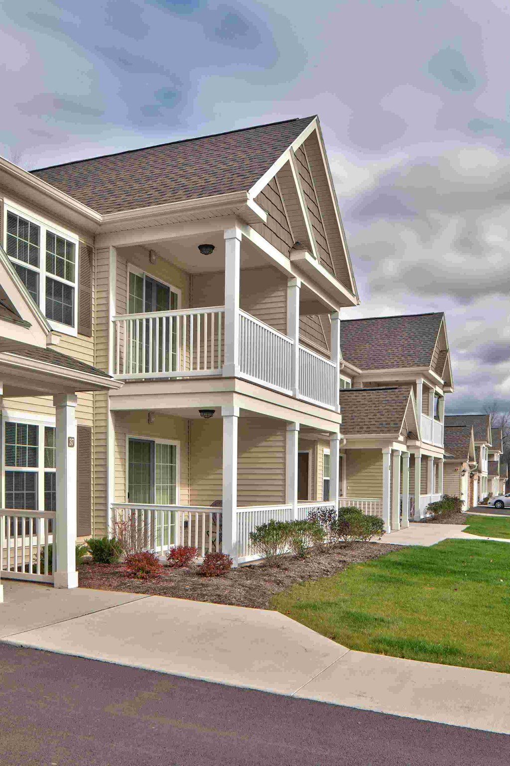 a row of homes with a porch and a sidewalk