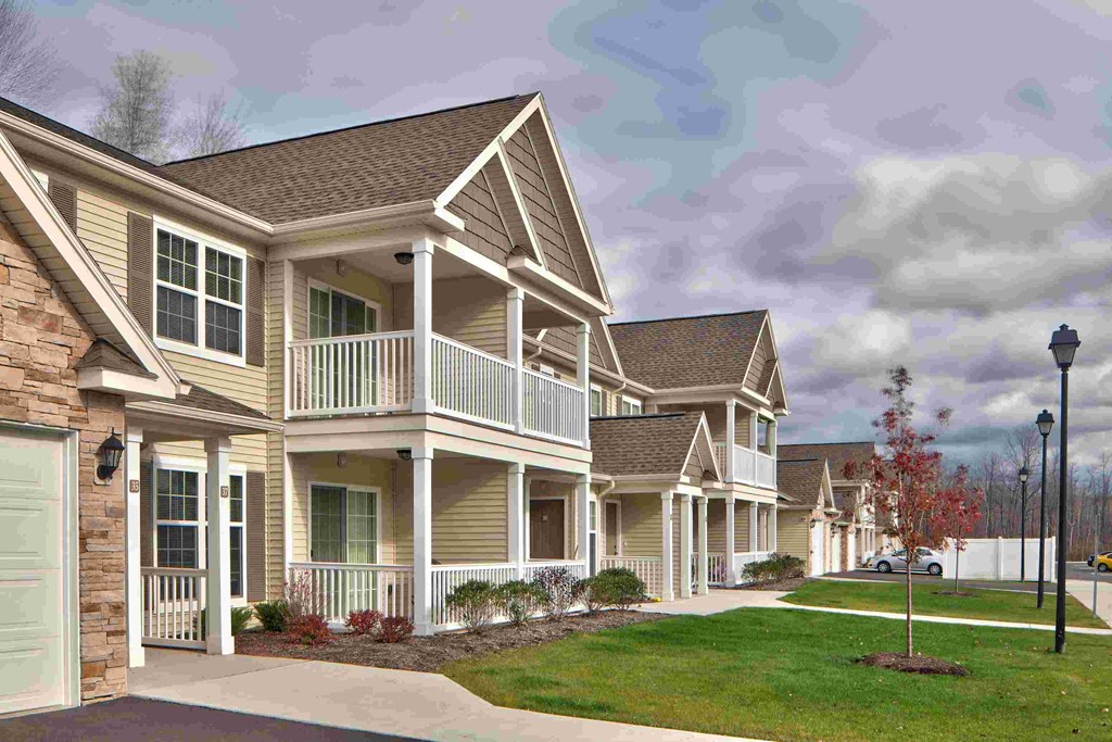 a row of homes in a subdivision with a sidewalk and lawn