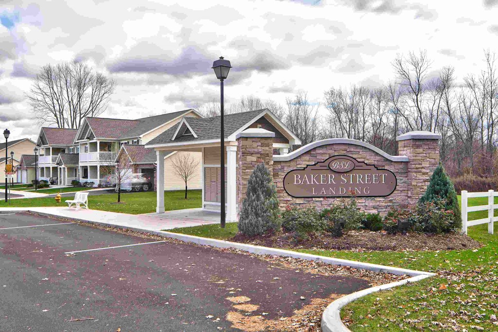 the street sign for baker street landing at the entrance to the community