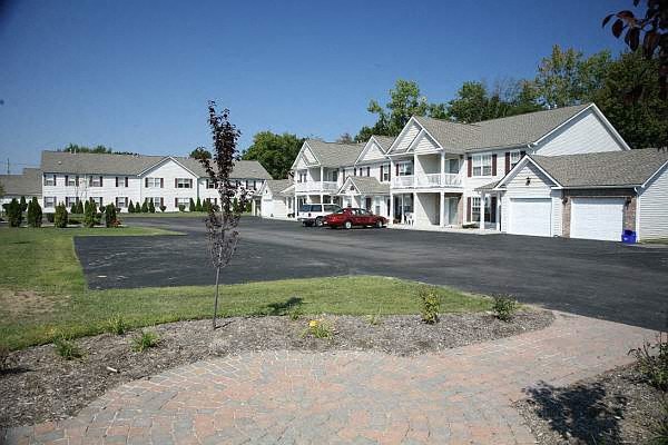 a red car parked in front of some houses