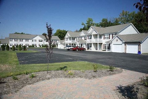 a red car parked in front of some houses