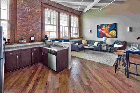 an open kitchen and living room with exposed brick walls and wood floors