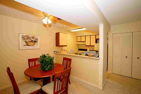 a dining room with a table and chairs next to a kitchen