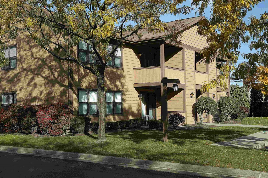 a large yellow house with trees in front of it