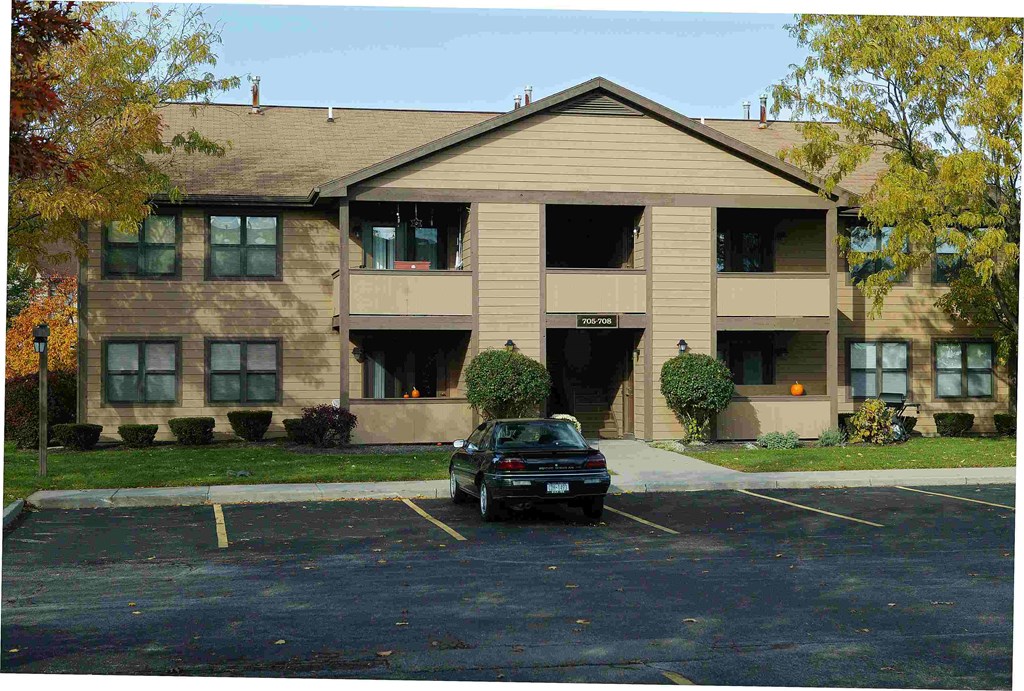 a car parked in a parking lot in front of an apartment building
