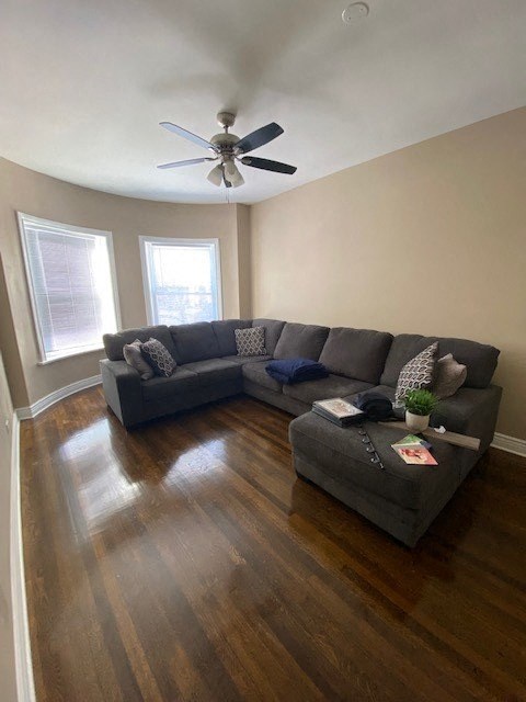 a living room with a couch and a ceiling fan