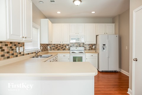 a kitchen with white cabinets and a white counter top