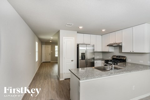 A modern kitchen with a stainless steel refrigerator and a sink.