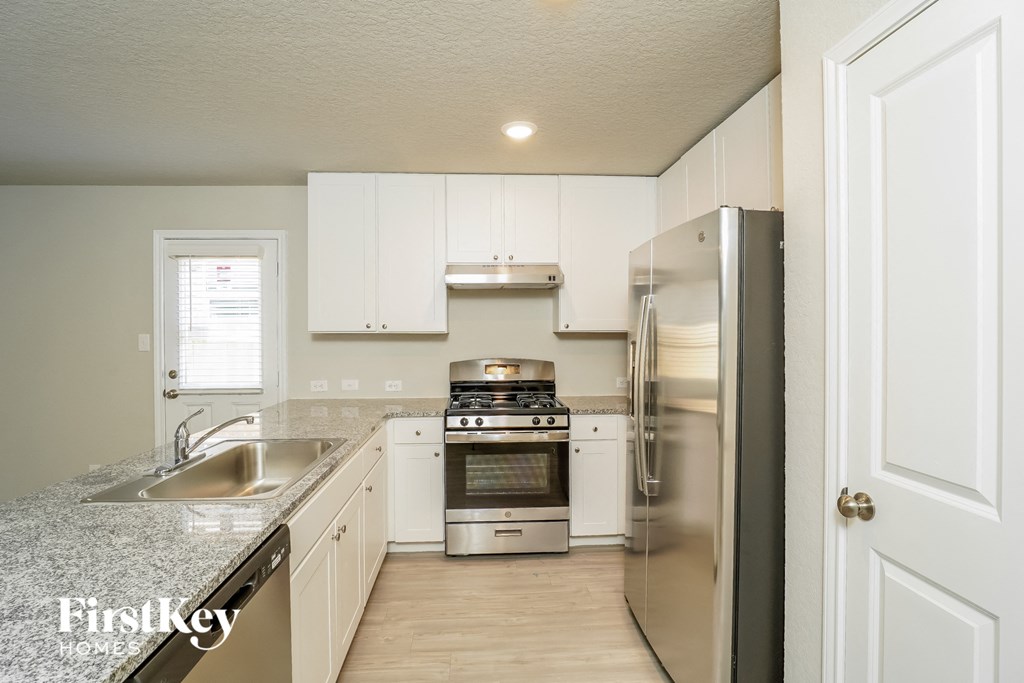 a kitchen with white cabinets and stainless steel appliances