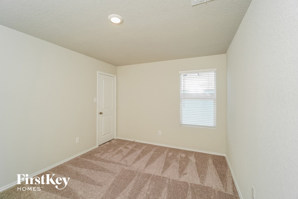 a bedroom with a carpeted floor and a white door