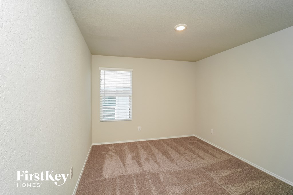 a bedroom with a carpeted floor and a window