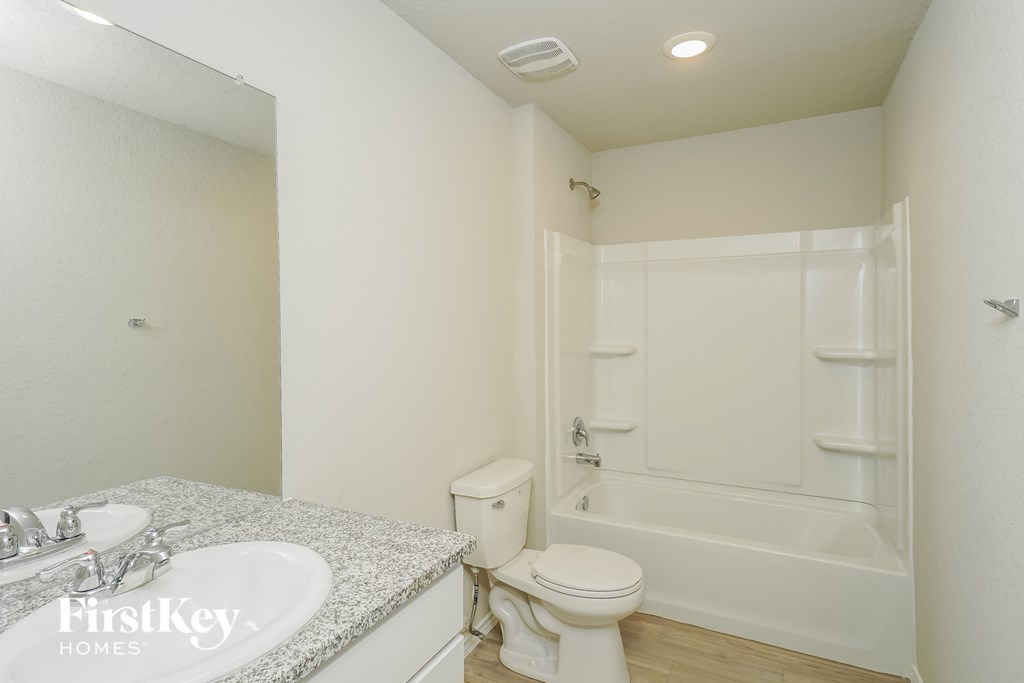 a bathroom with a toilet and a sink and a bath tub