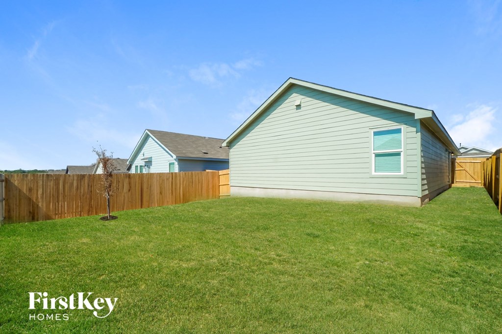 the backyard of a house with a fence and a yard