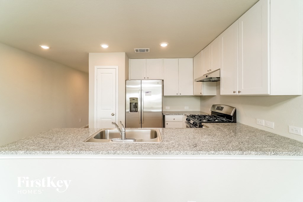 a kitchen with white cabinets and a sink and a refrigerator
