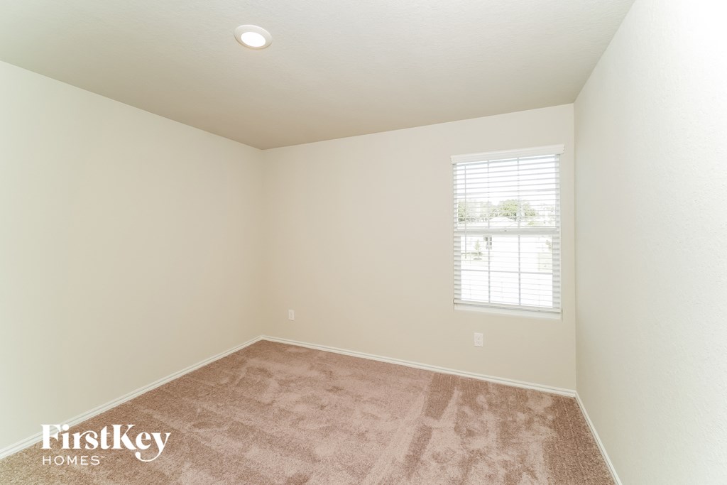 a bedroom with a carpeted floor and a window