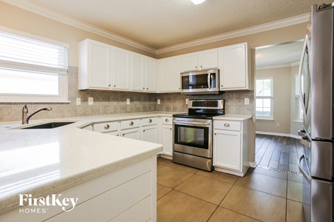 a kitchen with white cabinets and stainless steel appliances