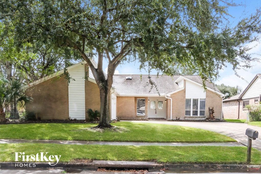 the front of a house with a tree in the yard