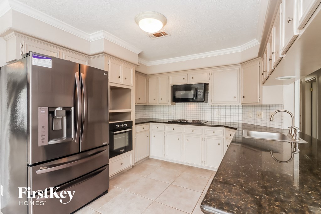 a kitchen with stainless steel appliances and white cabinets