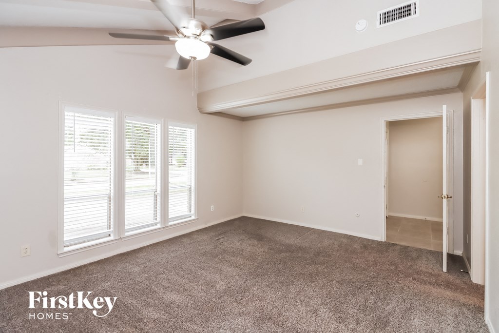 the living room of an empty house with a ceiling fan