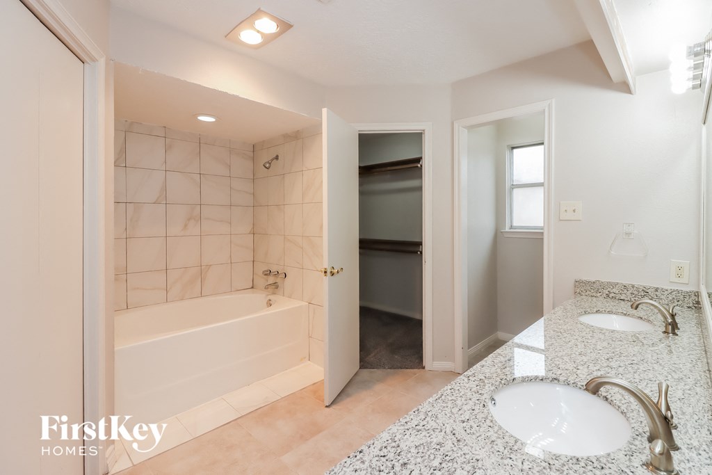a bathroom with two sinks and a tub and a shower
