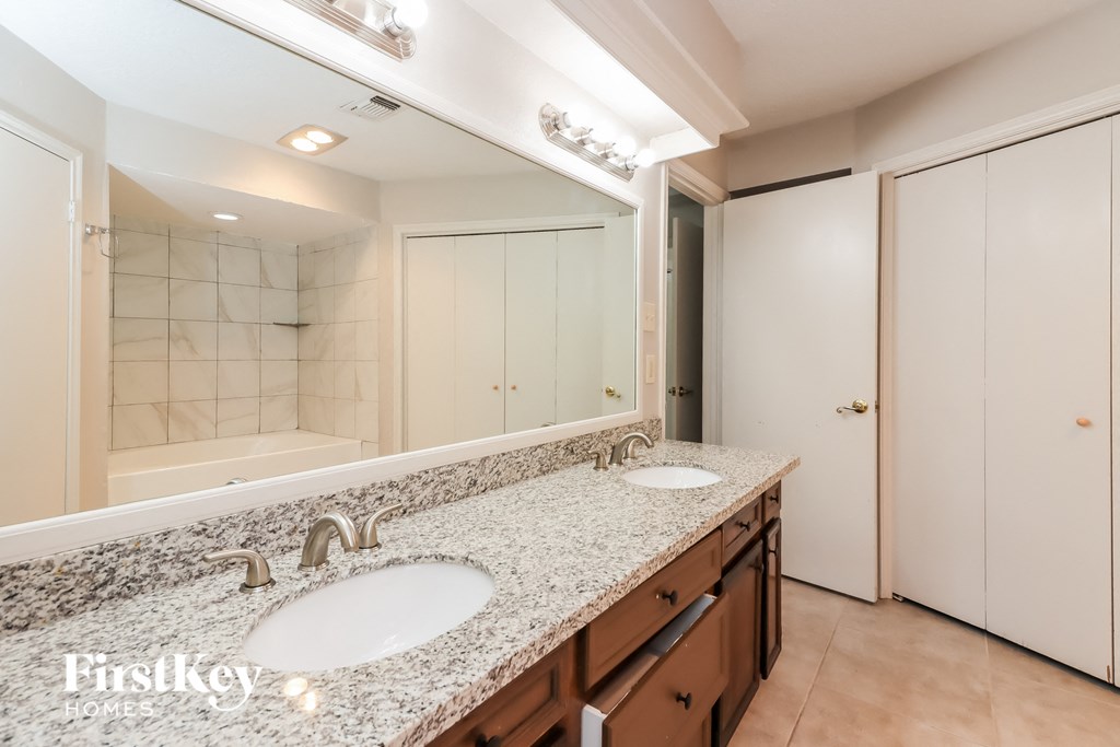 a bathroom with two sinks and a large mirror