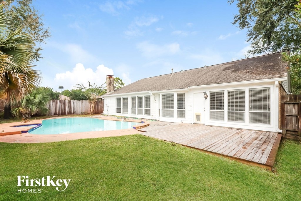 a backyard with a pool and a white house