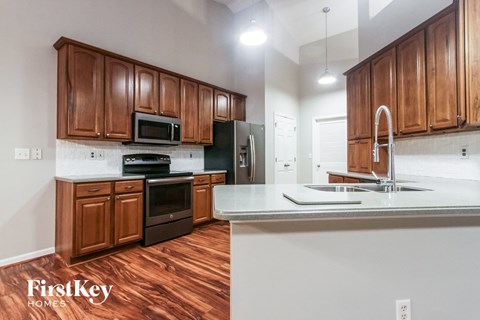 a kitchen with wooden cabinets and white counter tops and a sink