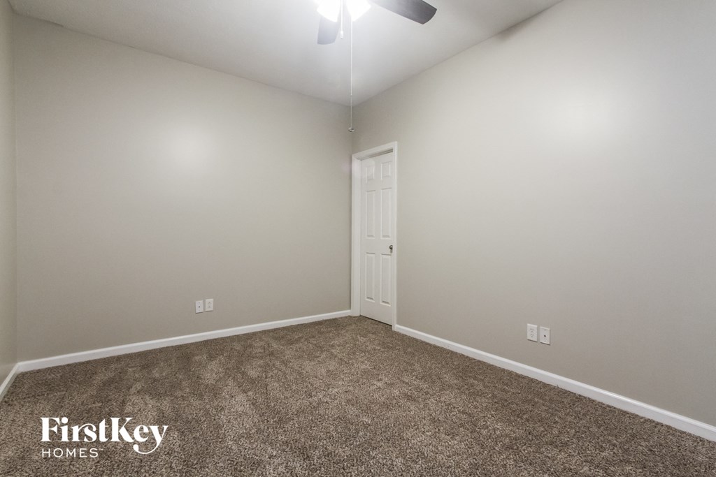 the upstairs bedroom has a carpeted floor and a door to the bathroom