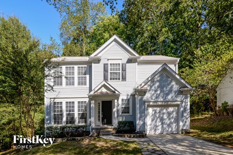 a white house with white shutters and a driveway