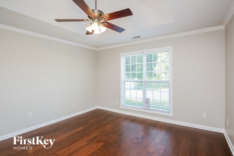 a living room with wood floors and a ceiling fan