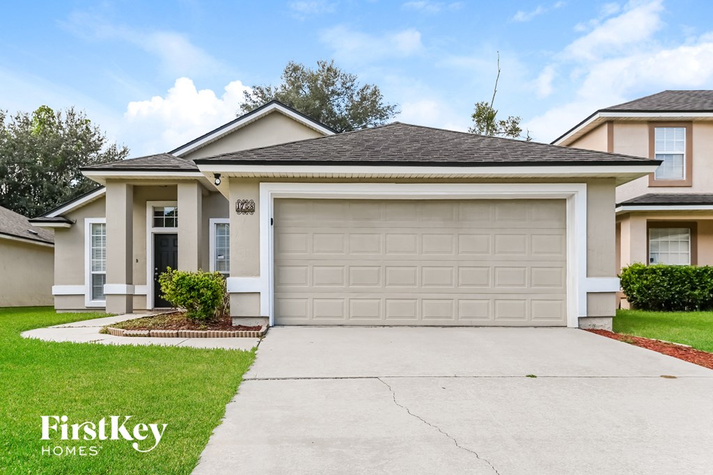 a white house with a garage door and a driveway