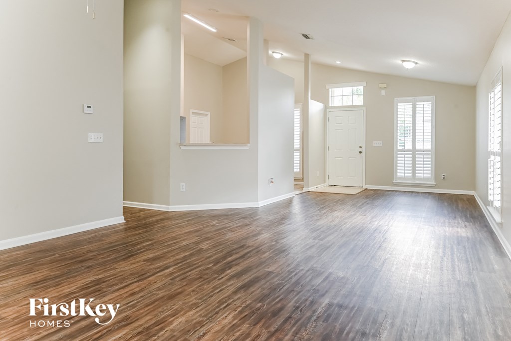 the living room and dining room of an empty house