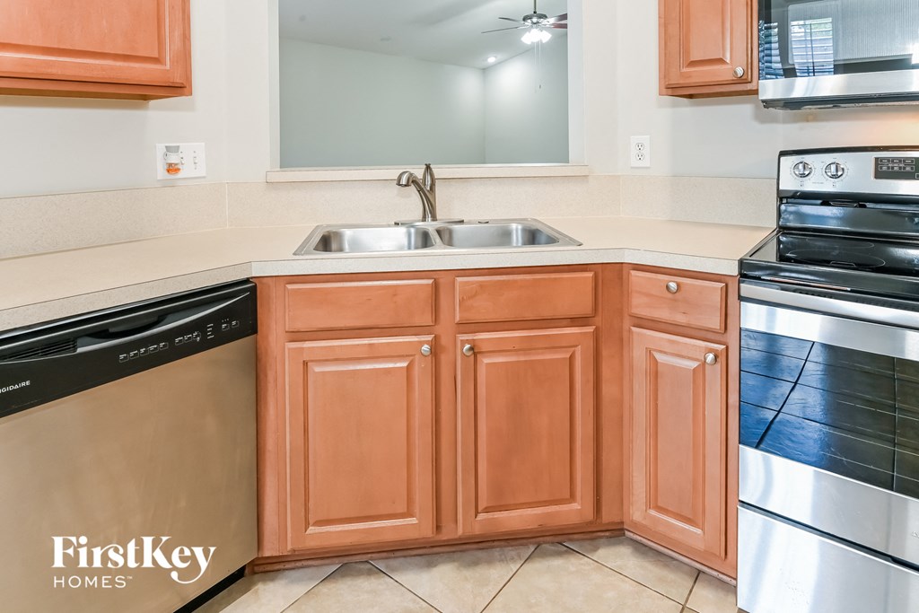a kitchen with wooden cabinets and a sink and a dishwasher