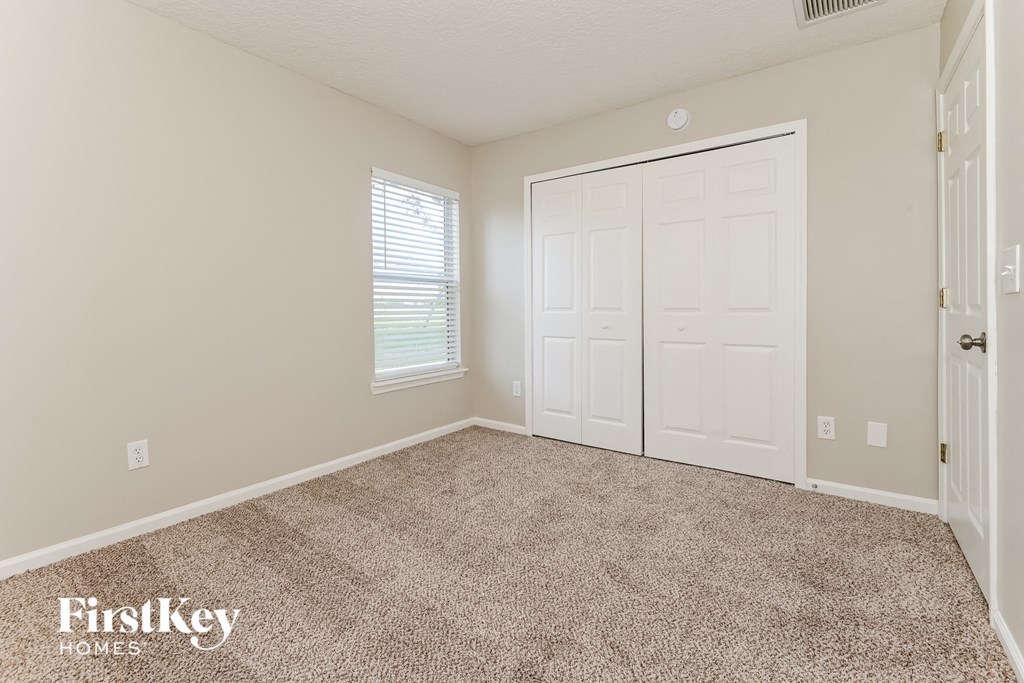 a bedroom with a carpeted floor and a white door