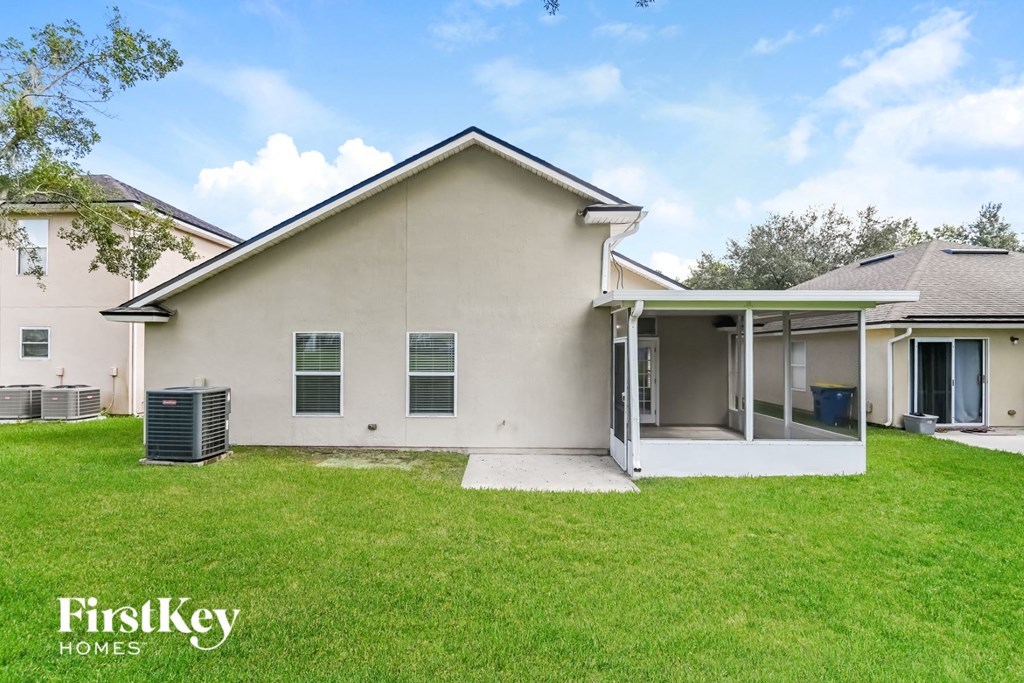 a white house with a grassy yard and a patio