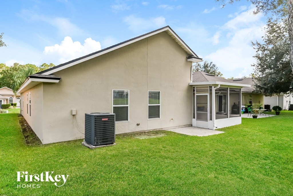 a side view of a house with a yard and a trash can