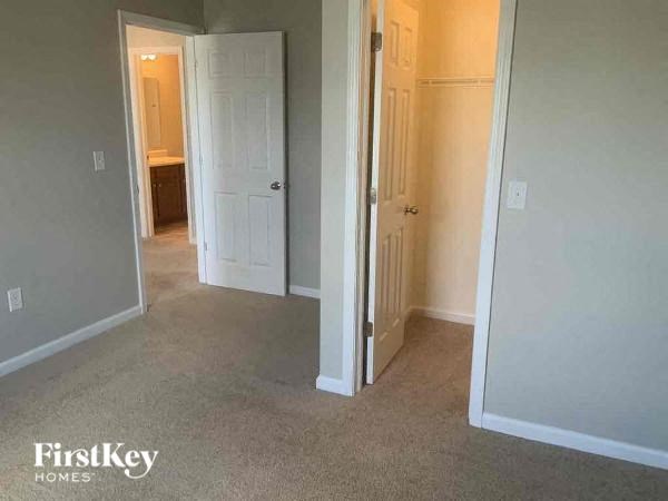 an empty bedroom with a door and a closet