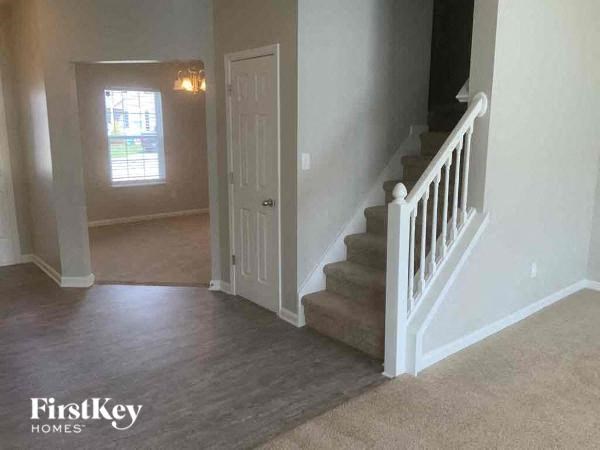 a hallway with a staircase and a white door