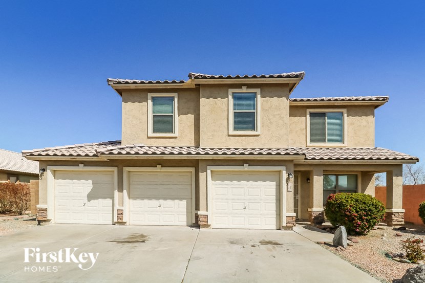 a beige house with white garage doors