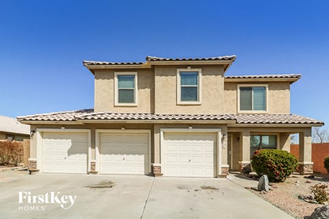 a beige house with white garage doors