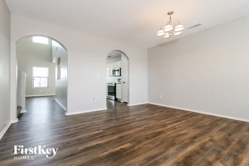 a living room with a hard wood floor and white walls