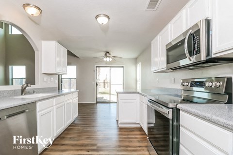 a kitchen with white cabinets and stainless steel appliances