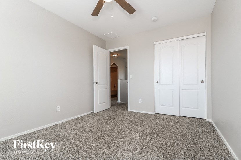 a bedroom with two closets and a ceiling fan