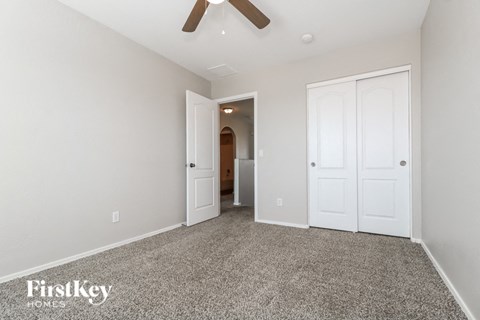 a bedroom with two closets and a ceiling fan