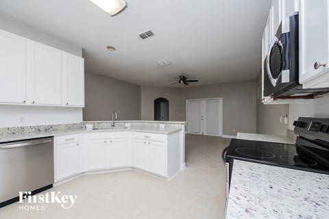 A kitchen with white cabinets and a black stove top.